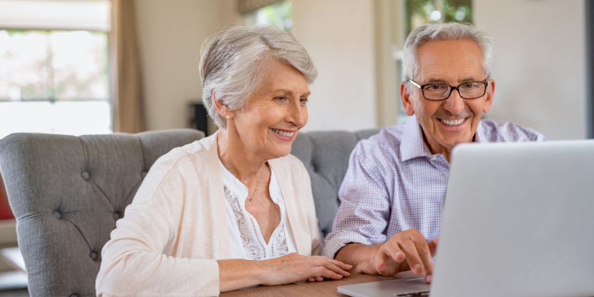 Older couple using a laptop together at home
