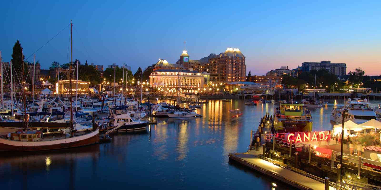 Victoria British Columbia Inner Harbour waterfront at dusk with boats and downtown buildings