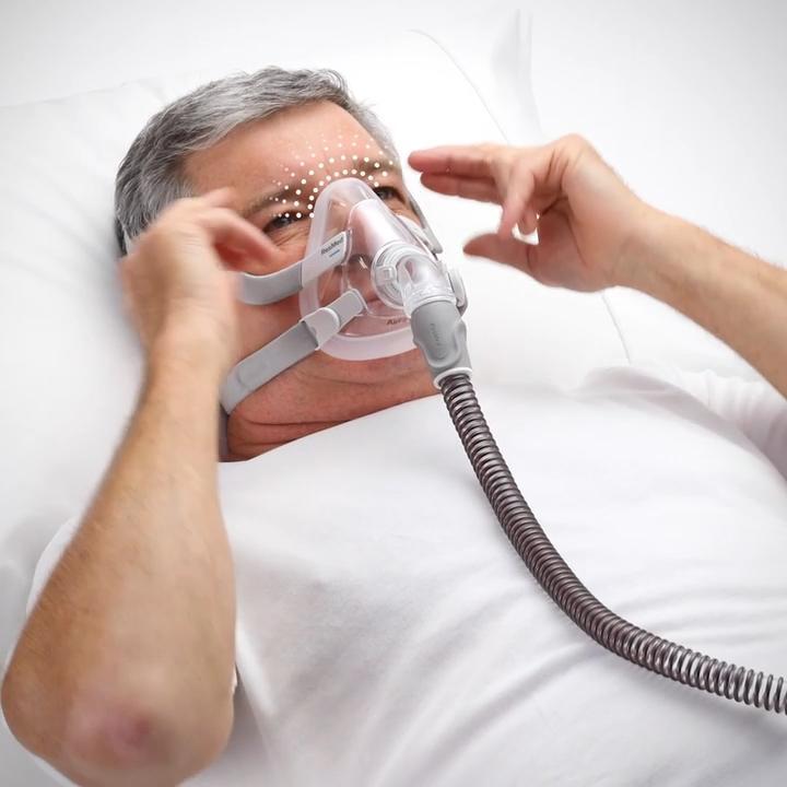ResMed AirFit F20 full-face CPAP mask being adjusted for fit